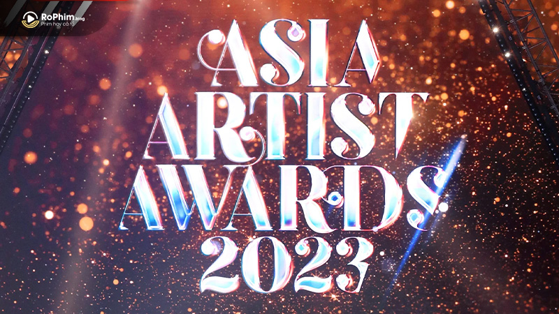 Sân khấu Asia Artist Awards 2023 với logo phát sáng trên nền ánh sáng vàng cam rực rỡ, ghi dấu sự kiện nổi bật trước AAA 2024.